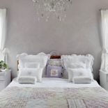 Chłodne kolory i romantyczne dekoracje, elegancka pościel i koronkowe poszewki na ozdobnych poduszkach.