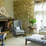 Choć dużo tu kamienia, udało sie przełamać rustykalny klimat. Elegancka otomana w roli stołu czy