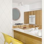 Kuchnia choć mała jest wielką dumą projektantki. Drewniane szafy mieszcza wszystko co trzeba, nawet... pralkę.