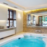 Ciekawy kontrast: ściany z cegły przeznaczonej na elewację i stylowa patynowana rama lustra.