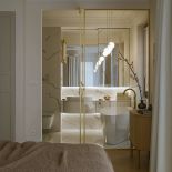 biała łazienka z ryflowanymi meblami przy sypialni