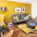 Ciepły palisandrowy parkiet i miodowa ściana. Do tego dizajnerskie meble. Sofa z Vitry, lampa marki