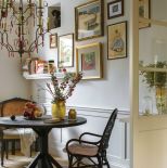 stół na tle mini galerii z obrazów