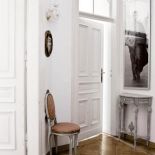 Czarno- białe portrety filmowych gwiazd zestawione z francuskimi, bogatymi meblami nadają wnętrzon lekkości.