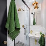 mała biała łazienka z czarnymi i złotymi dodatkami