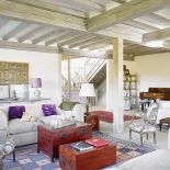 Czerwone elementy dominują na tle jasnych ścian i kanap.