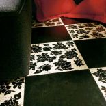 Dekoracja Stencil Lacca Nera: marmurowa płytka Biancone z kwiatami – 50 zł/szt., czarna płytka Makrame – 796 zł/m². YETI