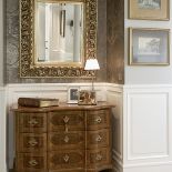 Dla przełamania dominującej czerni - antyczna brązowa komoda i lustro w barokowej ramie.