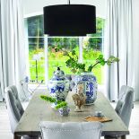 Do dużego masywnego stołu od firmy Jadik pasują fotele ze srebrnymi uchwytami z Decolor i kobaltowe wazony od Casa Mia.