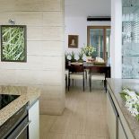 Do jasnych ścian i podłóg dobrano dla kontrastu ciemonobrązowy stół od Vinotti.