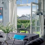 Do klubowych foteli pasowała szara sofa Lege artis. Szklane stoliki są z Romantic Home, stojące lampy z Amplex. Sztukaterie