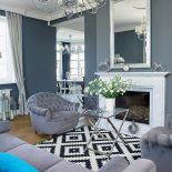 Do klubowych foteli pasowała szara sofa Lege artis. Szklane stoliki są z Romantic Home, stojące lampy z Amplex. Sztukaterie