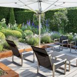 Do ogrodu idealnie dobrano małą architekturę. Tam, gdzie jest po miejsku, stoją chromowane fotele, a