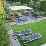 Do ogrodu idealnie dobrano małą architekturę. Tam, gdzie jest po miejsku, stoją chromowane fotele, a rabaty otoczone są