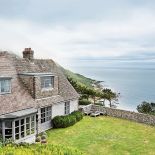 Dom na klifie urządzony jest eklektycznie: antyki, orientalne dodatki, klasyczna biel.