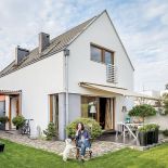 Dom na osiedlu gotowych domków ma prostą bryłę, a w środku urządzony jest i antykami i współczesnymi dizajnerskimi meblami.