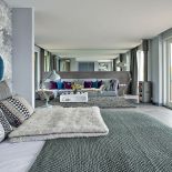 Dom nad jeziorem jest ogromny. Króluje w nim szarość, którą ogrzewają żółte dodatki i drewno z modrzewia syberyjskiego. Są