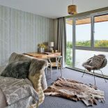 Dom nad jeziorem jest ogromny. Króluje w nim szarość, którą ogrzewają żółte dodatki i drewno z modrzewia syberyjskiego. Są