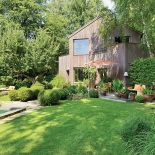 Dom obłożony modrzewiem komponuje się z otaczającą go zielenią.