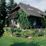 Dom otacza piękny ogródek. Powietrze, drewno i obrazy