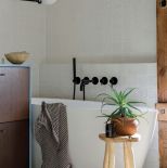 biała łazienka z drewnem i czarnymi akcentami