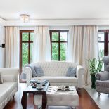 Dominują tu biel i delikatne szarości oraz błękity. W oknach długie zasłony.