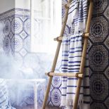 Leciutkie rattanowe fotele i ławki, kosze uplecione z morskich traw, lniana pościel w kolorze indygo,