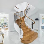 biały hol klasyczny z drewnianymi schodami