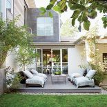 Drewniany podest, z którego jest zejście bezpośrednio na trawę ogrodu.