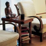 Drewniany posążek stoi na stoliku między dwoma fotelami.