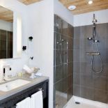 Drewnianych ścian szkoda zasłaniać. Płytkami wyłożono tylko kabinę prysznicową.