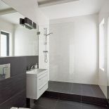 Duże, matowe płytki imitujące beton. Utzrymana w zimnej tomacji - biel, szarość i czerń.