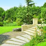 Duży dom w stylu amerykańskich rezydencji znika w bujnej zieleni.