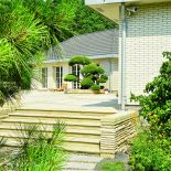 Duży dom w stylu amerykańskich rezydencji znika w bujnej zieleni.