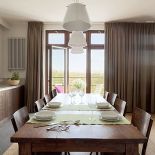 Duży rodzinny stół stoi między kuchnią a salonem.