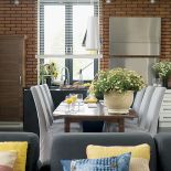 Duży, rozkładany stół przylega do wyspy kuchennej.