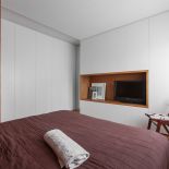 Dzięki drewnianemu regałowi, podłodze oraz wnęce sypialnia stała się bardziej przytulna.