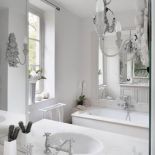 Dzięki lustrom i jednolitej, jasnej tonacji łazienka wydaje się nie tylko większa ale i wyższa.