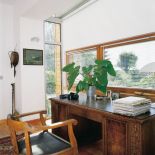 Dzięki przeszkleniu bocznych ścian gabinet pana domu został dosłownie wypchnięty do ogrodu.