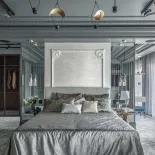 elegancka sypialnia z łóżkiem, tapetą w sztukateryjnej ramie i ścianą z lustrzanych płytek