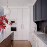 biała kuchnia z ciemnym drewnem i granatem