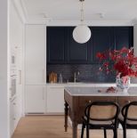 biała kuchnia z ciemnym drewnem i granatem