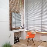 Sypialnia z ceglanymi ścianami i pomarańczowymi detalami.