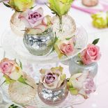 Etażerka z pastelowymi różami wygląda równie słodko, jakby ułożono na niej praliny.