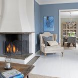 Fotel do czytania stoi przy kominku. Idealne miejsce!