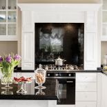 Fronty szafek świetnie zagrały z opalizującą złotem czarną powierzchnią granitu Star Galaxy na blatach i