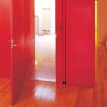Garderoba ukryta za czerwonymi panelami.