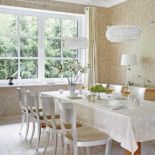 Harmonijnie, choć nie nudno. Kryształowe, eliptyczne lampy firmy Foscarini, kolonialny stół i klasyczne, srebrne krzesła.