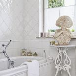 Łazienka w aranżacji rodem z Półwyspu Iberyjskiego: białe, hiszpańskie kafelki i XIX-wieczna rzeźba.