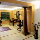 Hol urządzono przywiezionymi z Chin meblami. Stylowym dodatkien jest kolekcja lasek w barwnym pojemniku.